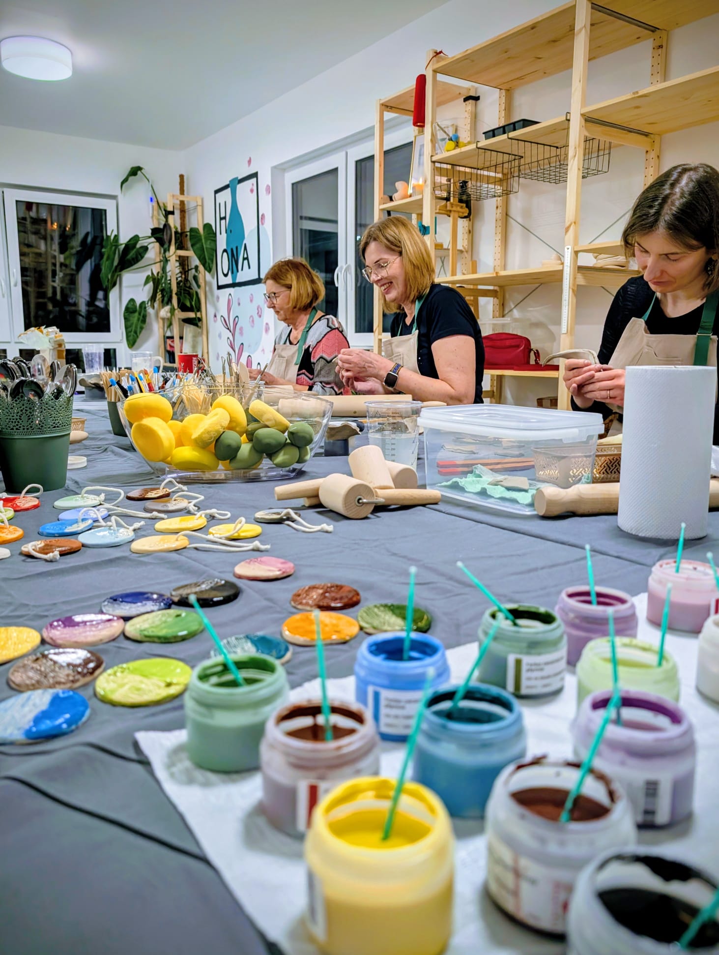 Farby ceramiczne i uczestniczki pracujące przy stole